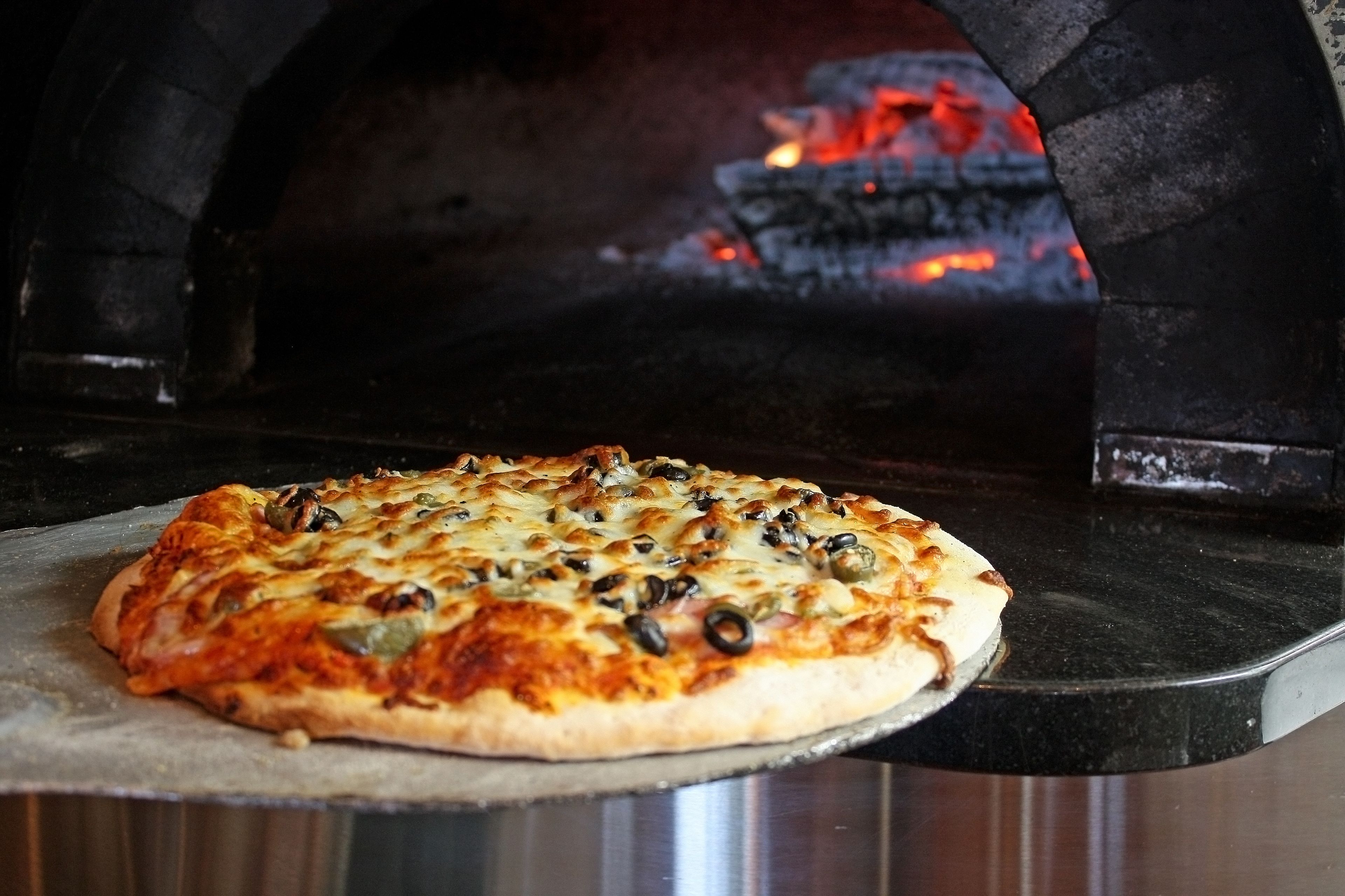 A pizza inside a brick oven.