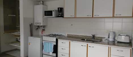 Réfrigérateur, micro-ondes (sur demande), four, plaque de cuisson