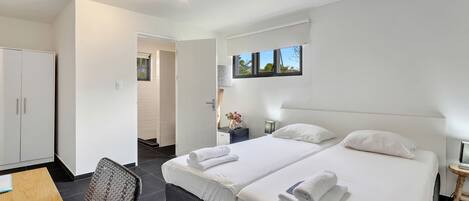 Una habitación de hotel moderna con dos camas, un escritorio y una silla.