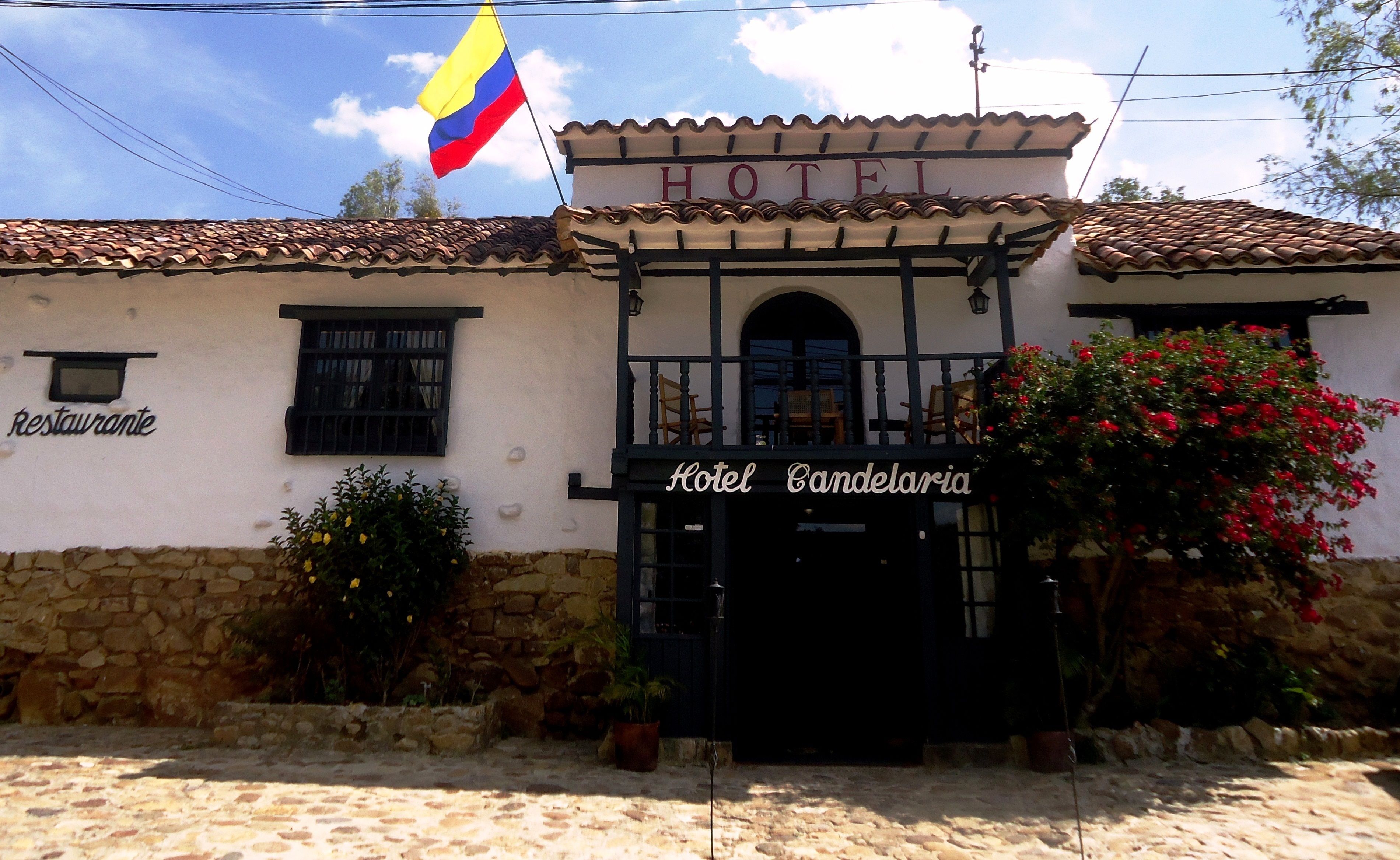 A building with a sign reading "Hotel Candelaia" and a flag above it.