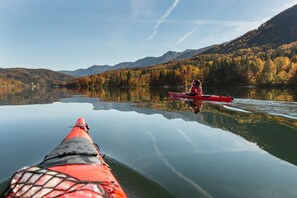 Kayak through the serene waters, surrounded by autumnal forests and majestic mountains.
