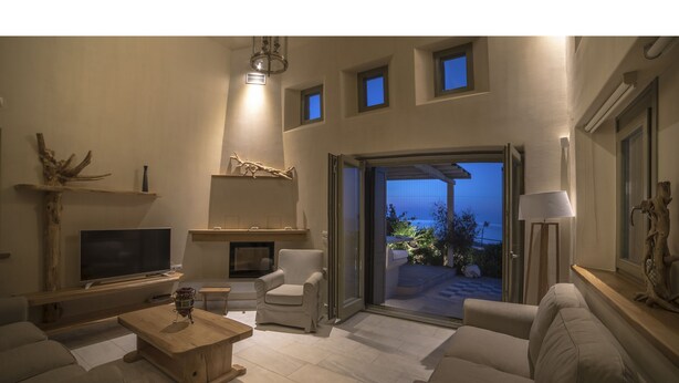 Una sala de estar moderna con chimenea, asientos cómodos y vistas al exterior.
