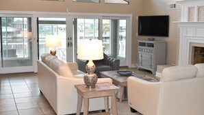 A spacious living room with a sofa, a coffee table, and a TV. - New Orleans Area Waterfront Retreat 117 Near the French Quarter/ Bourbon Street (Slidell)