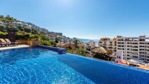 A swimming pool with clear blue water, surrounded by buildings and a clear sky. - Signature 406 Private Pool Sept 18-23 @ -50%, Oct 18-23 @ -40%, Nov 18-22 @ -25% (Puerto Vallarta,)