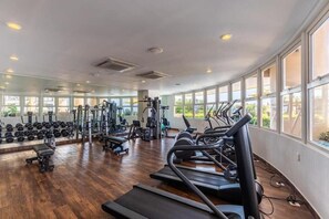 A gym with treadmills, weights, and exercise equipment.