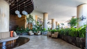 A spacious lobby with a curved seating area, large pillars, and a variety of plants. - Signature 406 Private Pool Sept 18-23 @ -50%, Oct 18-23 @ -40%, Nov 18-22 @ -25% (Puerto Vallarta,)