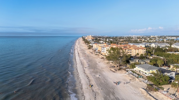 Eine Küstenstadt mit Strandhäusern, einem Sandstrand und Blick auf den Ozean.