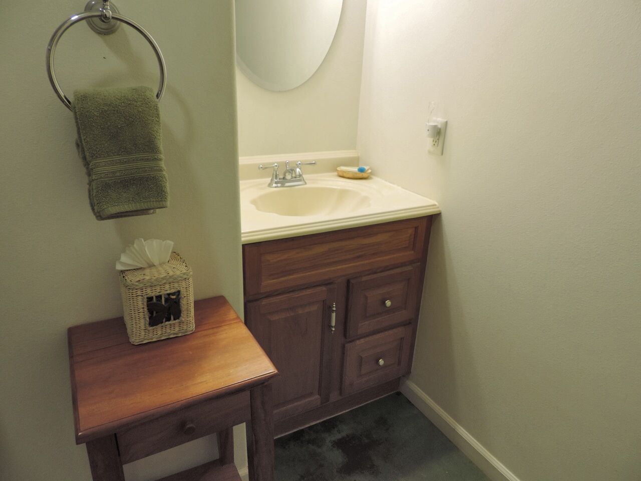 A bathroom with a wooden vanity, a sink, and a mirror.