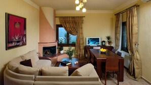Un soggiorno con divano, camino, televisione e tavolo da pranzo.