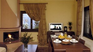 Zona pranzo con camino, televisione e tavolo apparecchiato per la colazione.