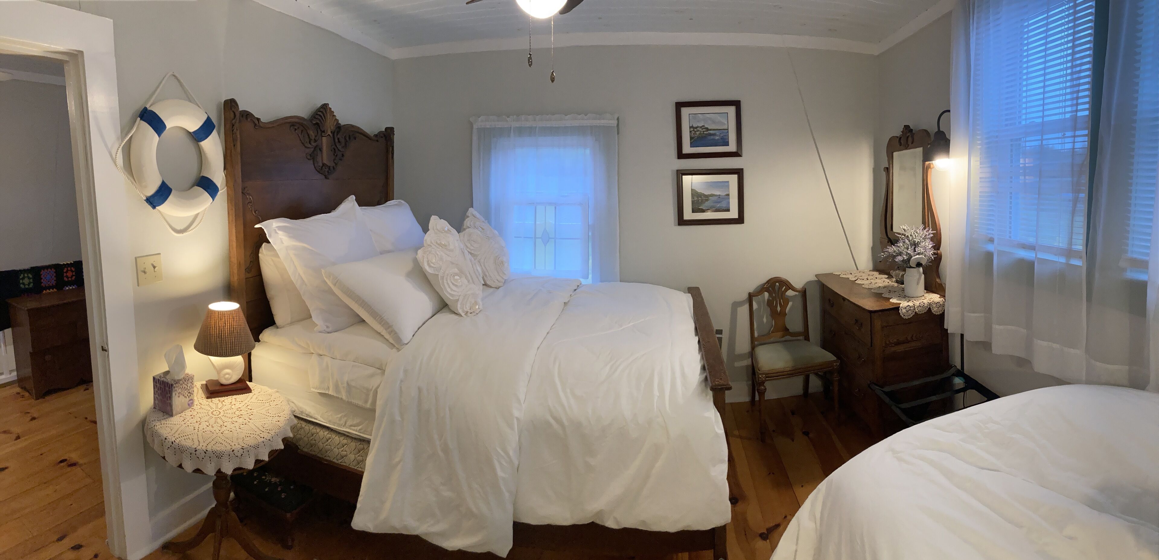 Un dormitorio con una cama de madera, una mesita de noche con lámpara, una silla y un aparador.