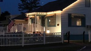 Una casa con porche, una bandera y una valla.