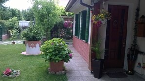 A house with a well-maintained garden, a brick pathway, and a door with hanging flower baskets. - Venice Holiday Home, free wi-fi, private garden, romantic and affordable. (Mogliano Veneto)