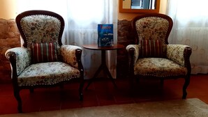 Two upholstered chairs with floral upholstery and striped cushions, a small round table, and a book titled "Venice" on the table. - Venice Holiday Home, free wi-fi, private garden, romantic and affordable. (Mogliano Veneto)