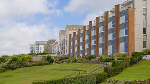 Une rangée d’immeubles d’appartements modernes, avec un jardin bien entretenu à l’avant.