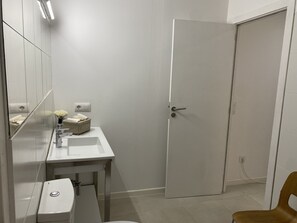 Regadera, secadora de cabello, toallas, papel de baño 