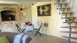 Una sala de estar con chimenea, un sofá, una mesa de centro y una escalera.