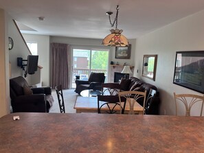A living room with a sofa, chairs, a coffee table, a TV, a fireplace, and a large window. - Luxury Mountain Home  Mountain Views Free Wifi (Silverthorne)