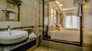 A hotel bathroom with a large sink, mirror, and shower. - Sapa Delta Hotel (Sa Pa)