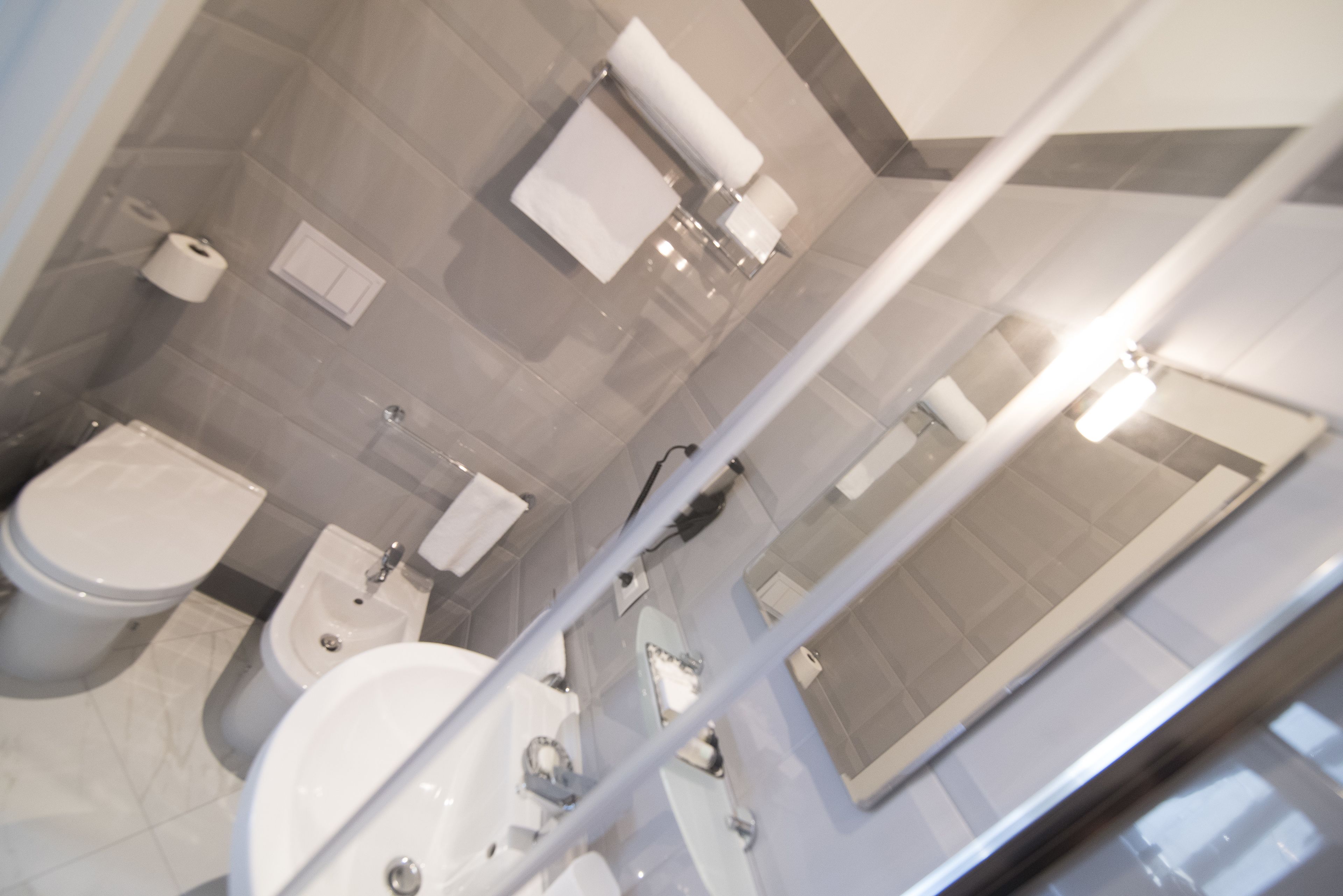 A modern bathroom with a toilet, bidet, and sink.