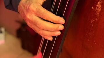 Eine Hand hält ein Cello in Nahaufnahme.