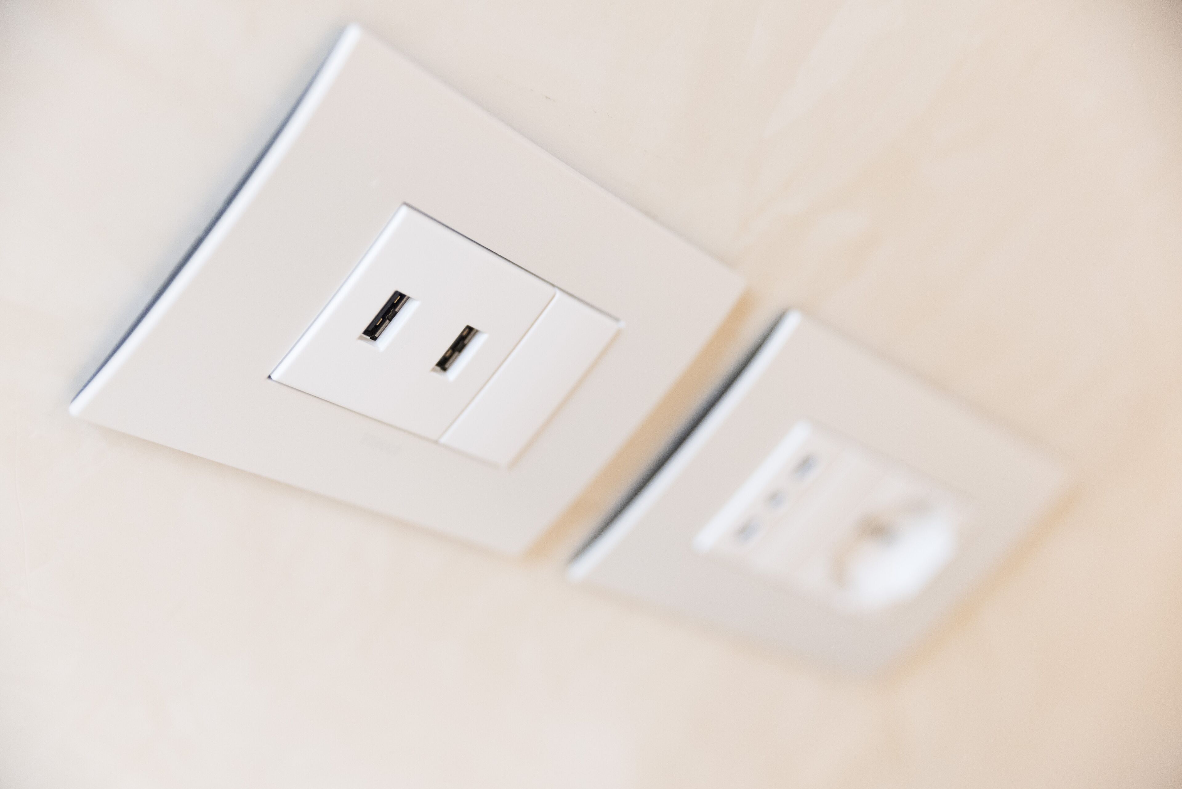 Une prise électrique blanche, dotée de deux fiches et d’un interrupteur.