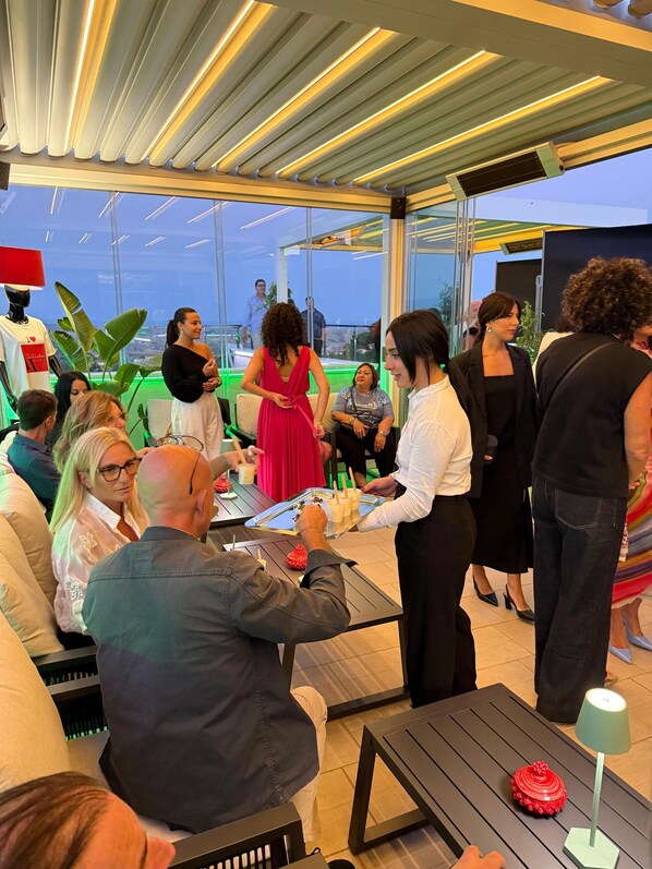 A modern indoor space with a glass ceiling, seating areas, and a table with drinks. - Altavilla Boutique Hotel (Catanzaro)
