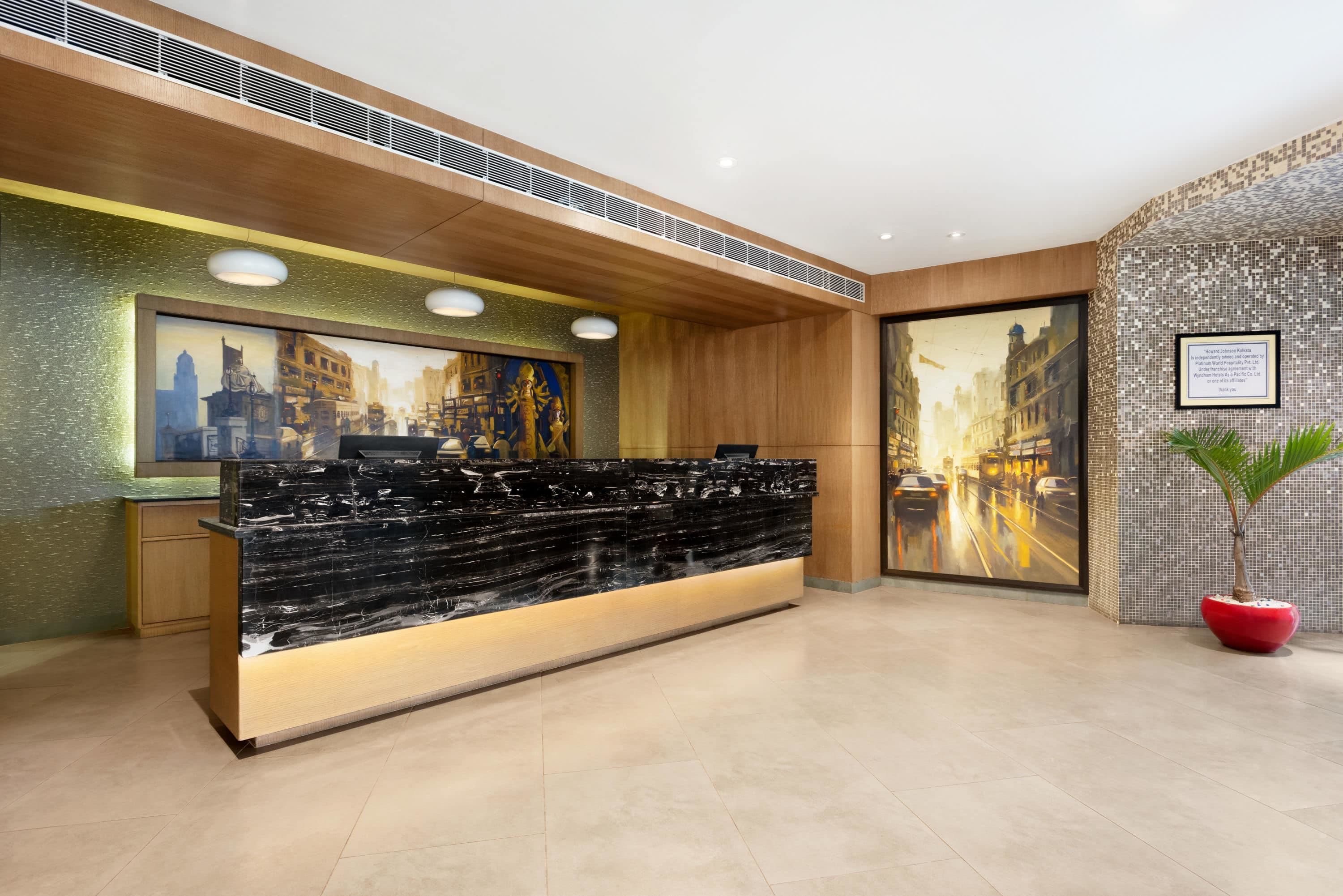 A reception desk with a marble top, wooden paneling, and artwork on the walls.