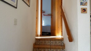 Uma escadaria com ladrilhos estampados que leva a uma porta aberta.