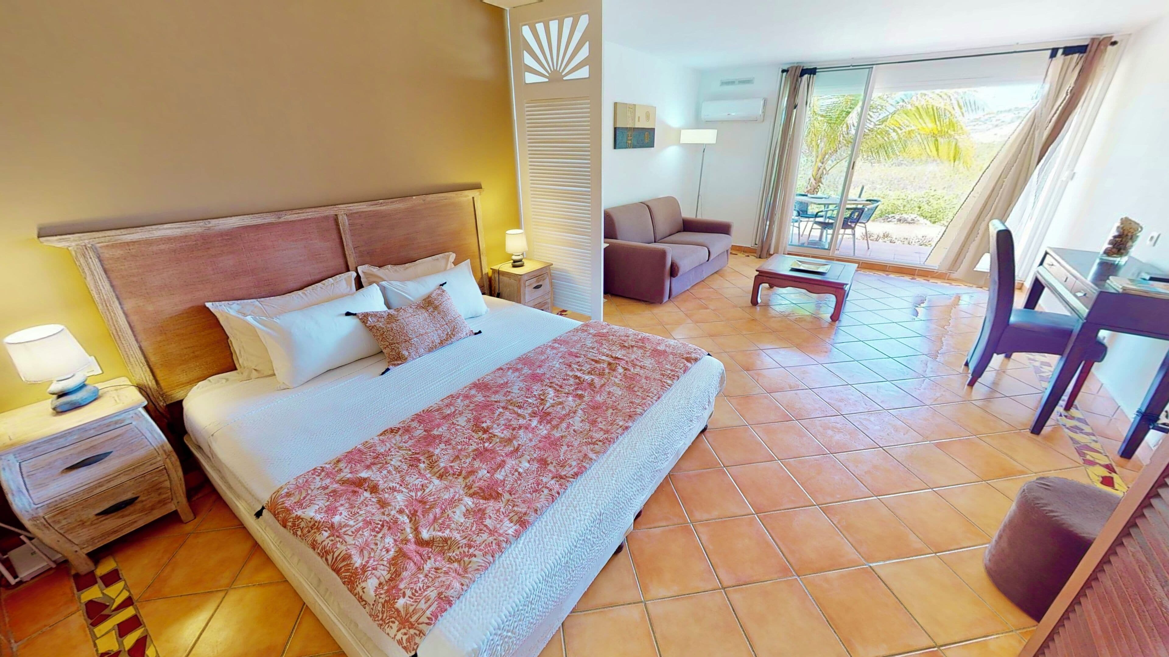 Ein Hotelzimmer mit einem großen Bett, einem Schreibtisch, einem Sessel und einer Couch.