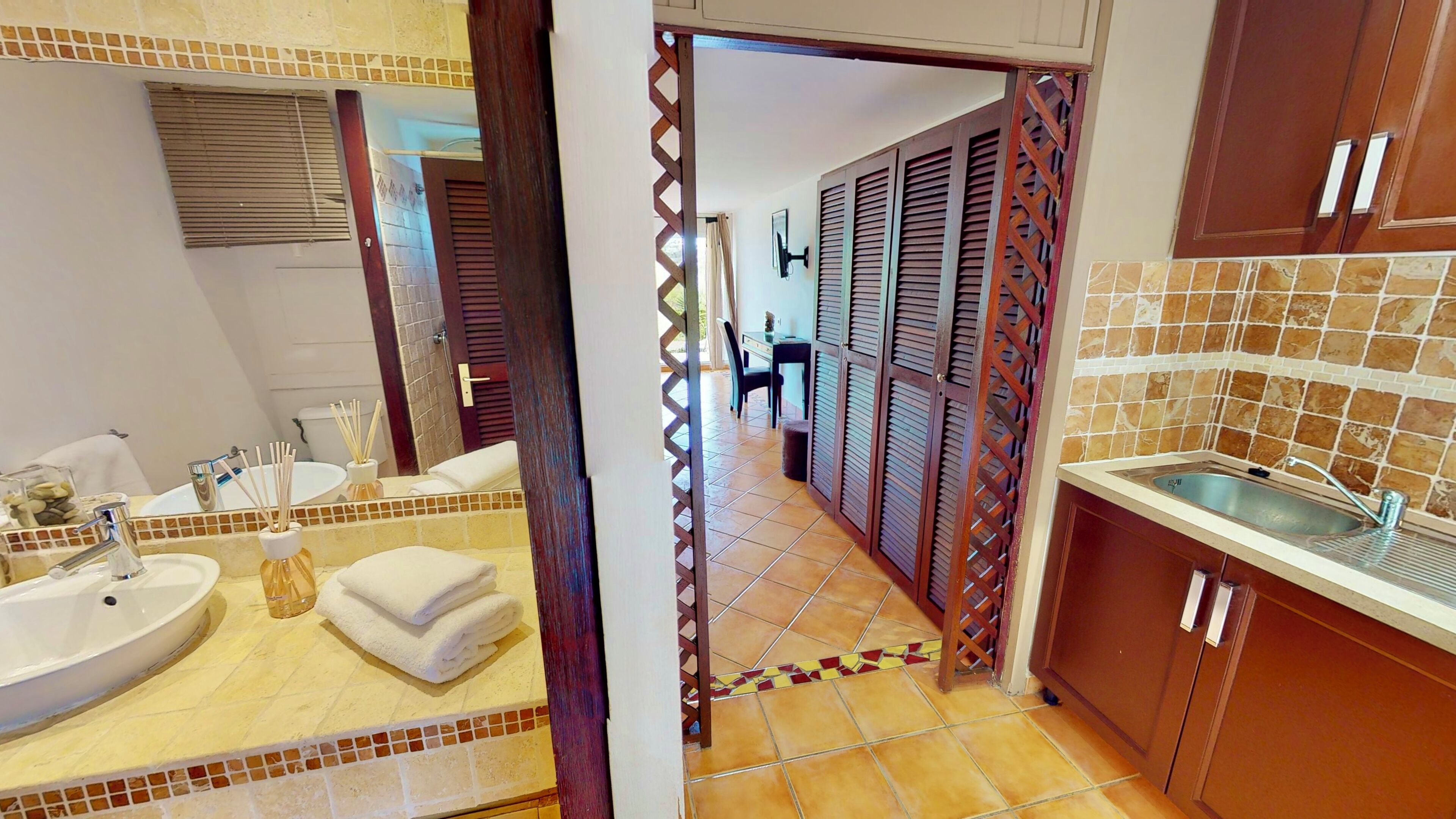 A bathroom with a sink, mirror, and towel stack.