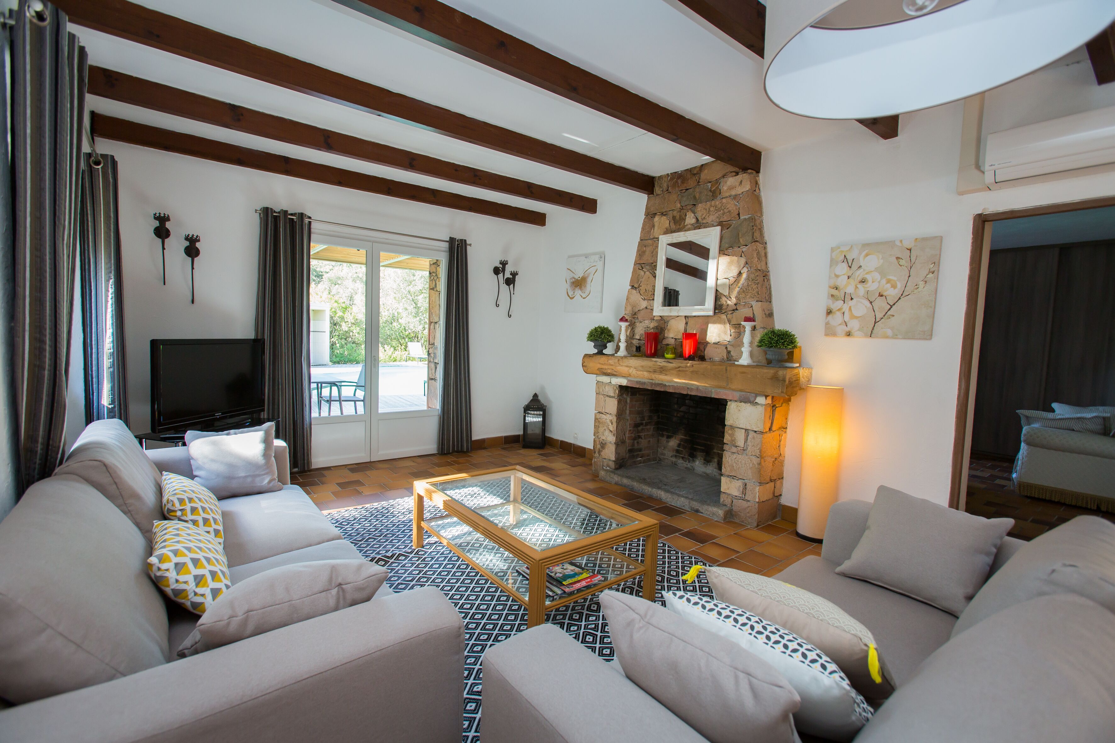 A living room with a stone fireplace, a television, and a sofa set.