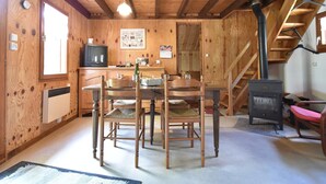 Un interior de madera con una mesa de comedor, sillas, un televisor y una chimenea.