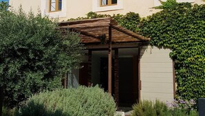 A two-story building with a covered entrance and a garden area. - Villagehouse, AC, pool, unoverlooked patio, stores restaurants walking distance (Saint-Nazaire-D'aude)