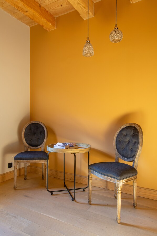 A room with two wooden chairs, a small round table, and hanging lamps. - Magnificent XVIIIth century farmhouse, in the heart of the Alsace vineyard. (Epfig)