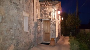 A stone building with a wooden door, a small porch, and a large vase on the ground. - Mas Mougins, near Cannes, very bright with quality fittings (Mougins)