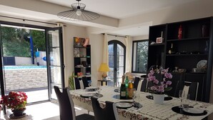A dining area with a table set for four, a potted plant, and a bookshelf. - Mas Mougins, near Cannes, very bright with quality fittings (Mougins)