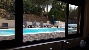 A view of a swimming pool with lounge chairs and a stone wall. - Mas Mougins, near Cannes, very bright with quality fittings (Mougins)
