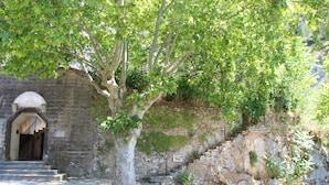 A stone building with a staircase leading to an arched entrance.