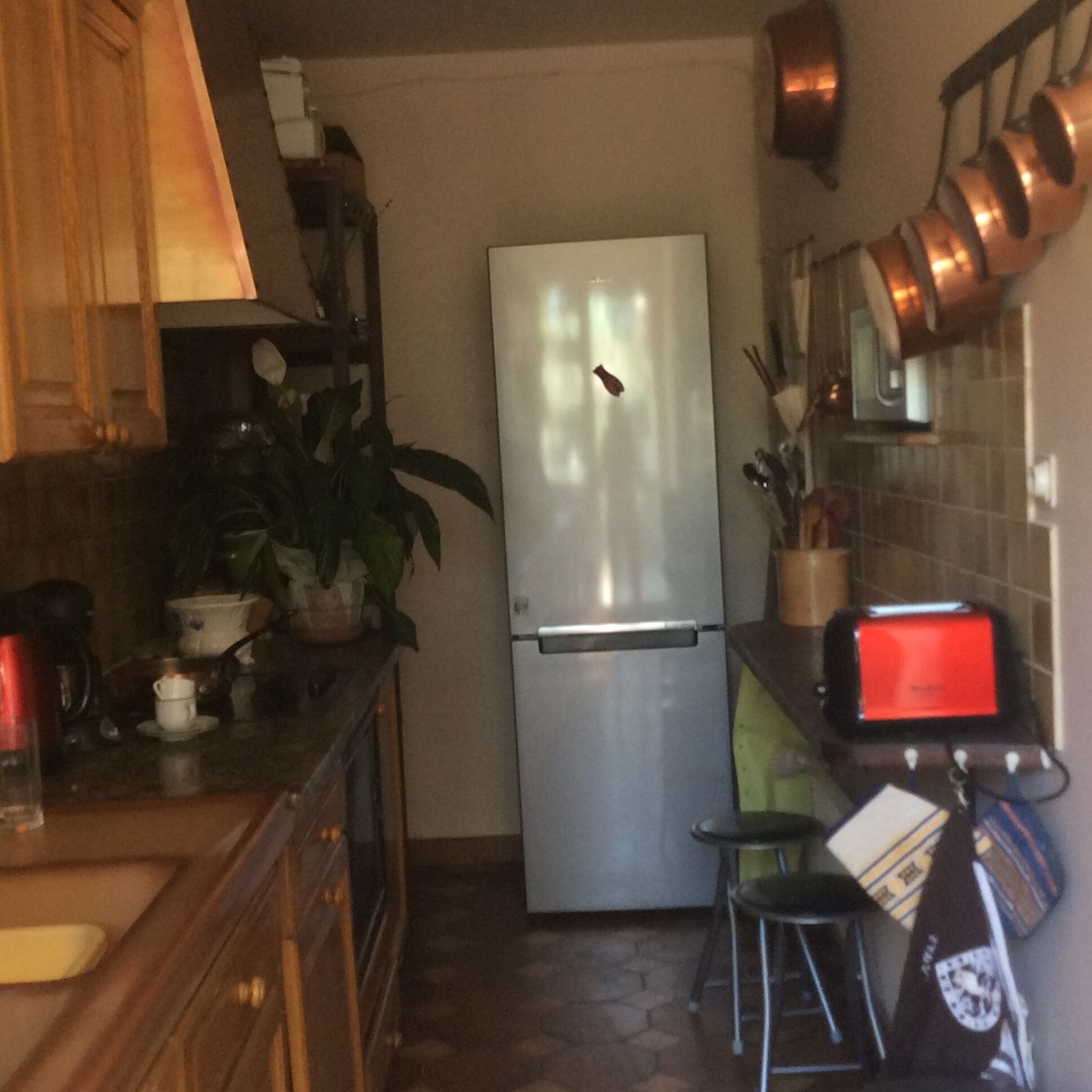 A compact kitchen with a refrigerator, a coffee maker, and a toaster.