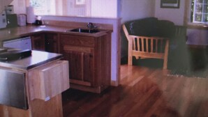 Une pièce avec une grande fen être, un piano et une petite table.