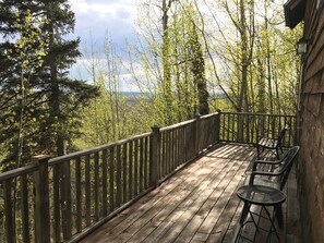 A wooden deck with a railing, surrounded by trees and a view of the landscape. - Birchcrest Cabin On Unique Ridge Top With Views of Denali and the Alaska Range (Talkeetna)