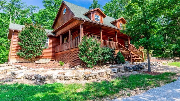 A log cabin with a porch, stone foundation, and surrounding greenery. - Sleeps 12, Pool, Marina, Quiet Side of Table Rock (Cassville)