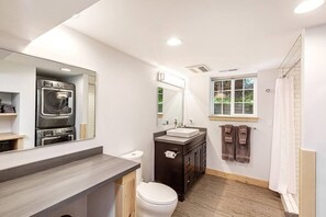 A modern bathroom with a built-in oven, a large mirror, a sink, and a shower area. - Clean, Private, Historic, Downtown Bozeman Home (Bozeman)
