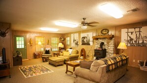 A cozy living room with a fireplace, comfortable seating, and a decorative rug.
