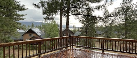 Una terraza de madera con vista a casas y árboles.
