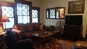 A living room with a leather sofa, a wooden coffee table, and a television.