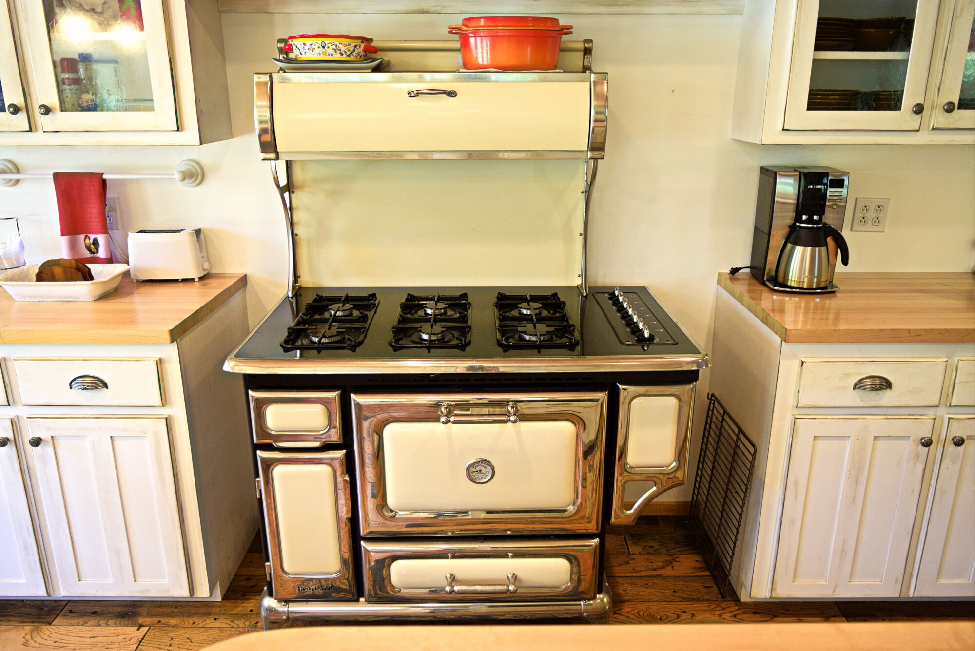 A vintage stove with four burners, a range hood, and a built-in oven.