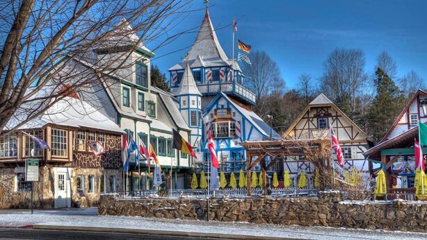 A traditional European-style building with a stone facade, a prominent tower, and multiple flags. - White Water River Cabin near Helen, GA-Kayak, tube, fish, hike, in wine country (Cleveland)