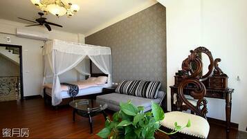 Cozy retreat with a bed, sofa, and wooden dresser, complete with a ceiling fan and air conditioning for a comfortable stay.